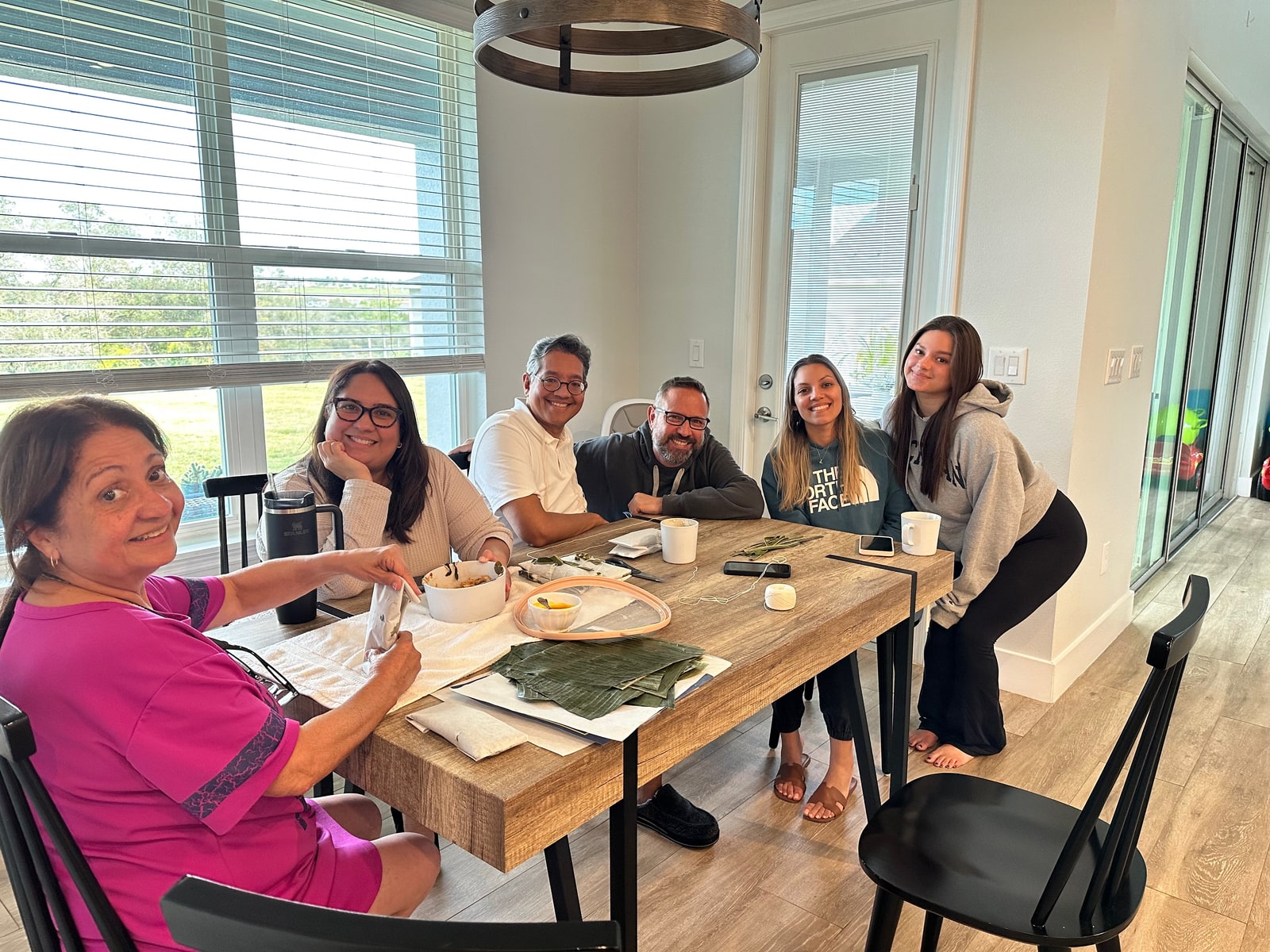 La familia reunida alrededor de la mesa mientras prepara pasteles en Florida.